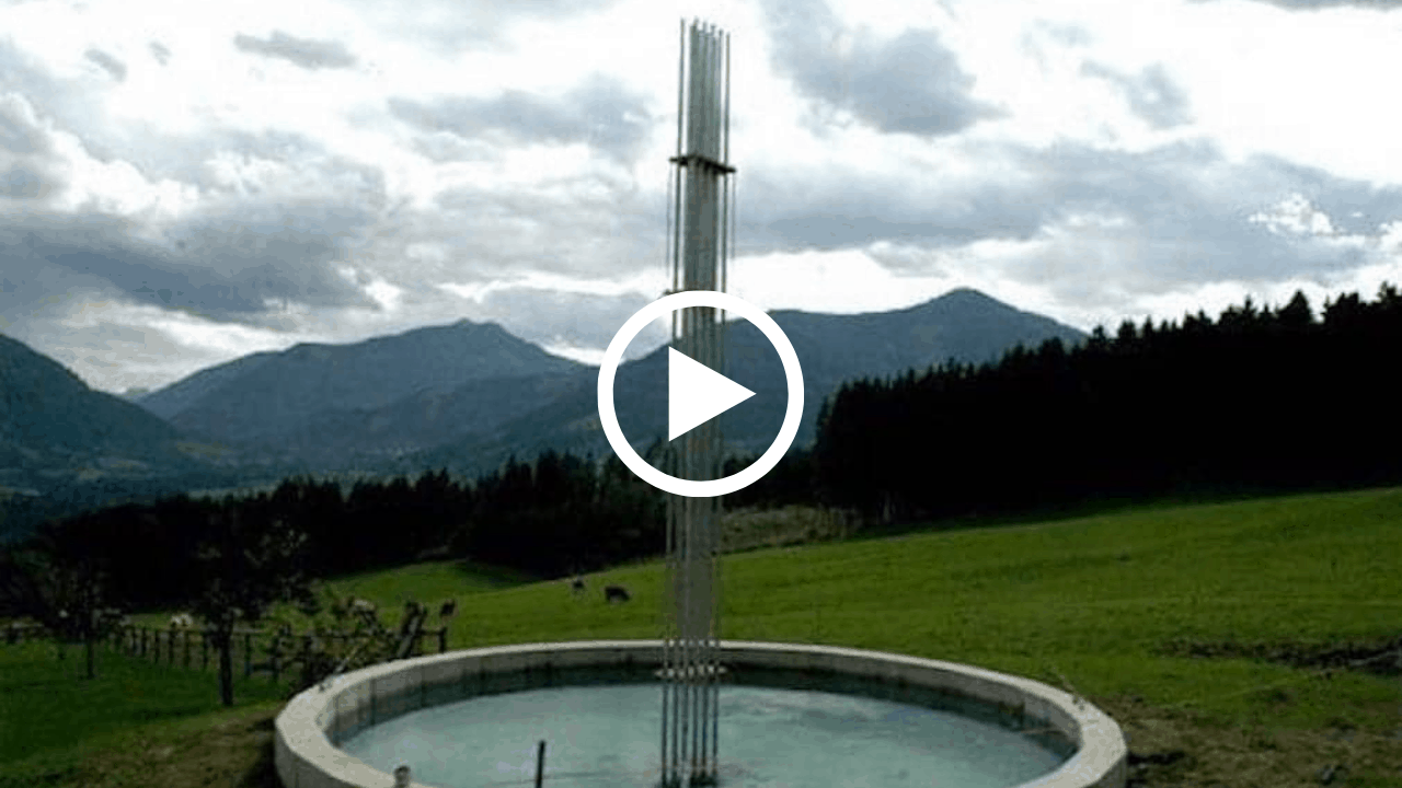 Metal water fountain with a mountain backdrop, symbolizing holistic environmental healing and nature connection.